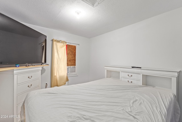 bedroom with cooling unit and a textured ceiling