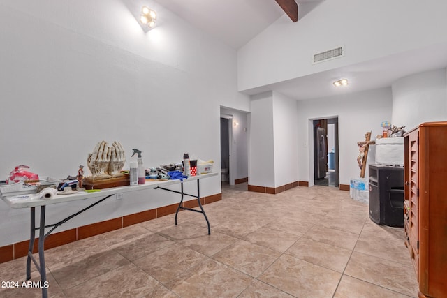 interior space featuring high vaulted ceiling, beam ceiling, and light tile patterned floors