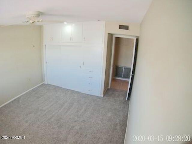 14409 N Mcphee Dr, Sun City, AZ 85351 - unfurnished bedroom with light carpet, baseboards, and a closet