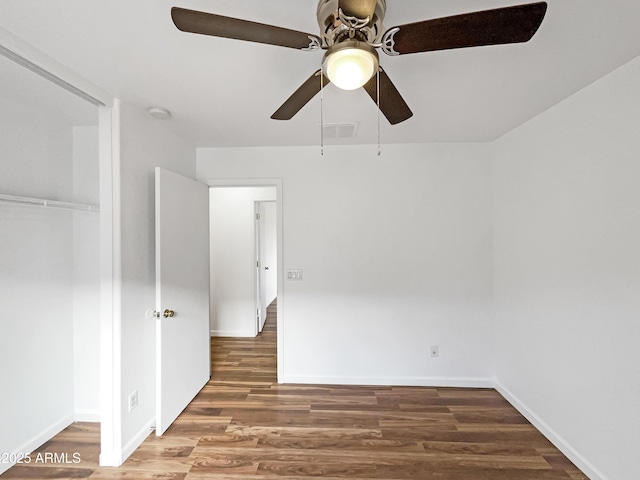 unfurnished bedroom featuring ceiling fan, dark wood-type flooring, and a closet