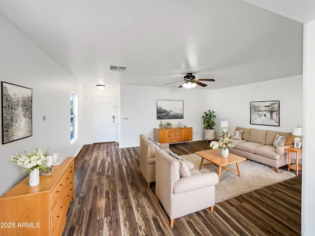 living room featuring ceiling fan and dark wood-type flooring