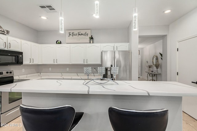 kitchen featuring light tile patterned floors, appliances with stainless steel finishes, white cabinetry, and light stone countertops