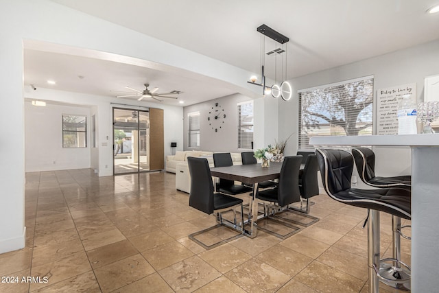 dining space featuring ceiling fan with notable chandelier and light tile patterned flooring