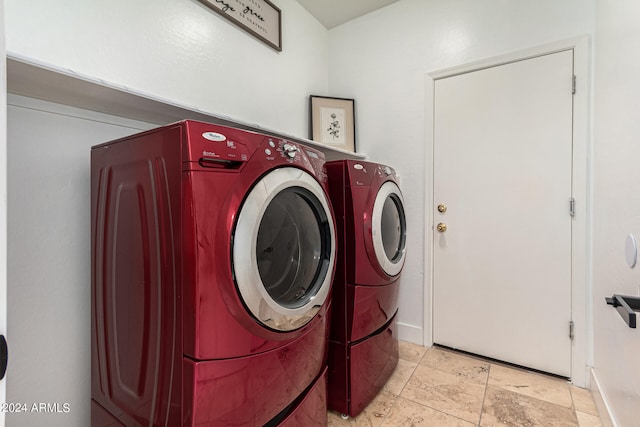 clothes washing area featuring washer and dryer and light tile patterned flooring