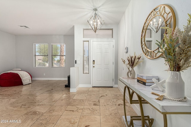 tiled foyer entrance with a notable chandelier