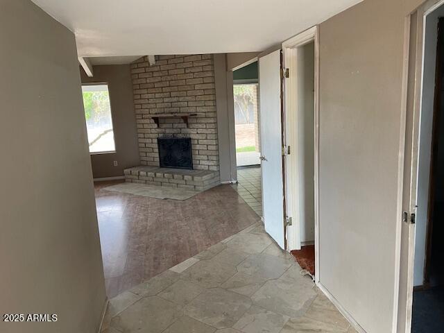 unfurnished living room featuring a fireplace and baseboards