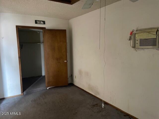 unfurnished bedroom featuring a textured ceiling, a closet, and a wall mounted air conditioner