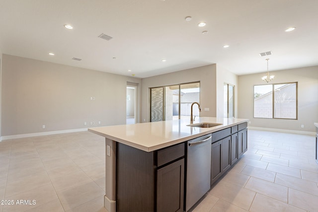 kitchen with light tile patterned flooring, dark brown cabinetry, sink, stainless steel dishwasher, and a kitchen island with sink