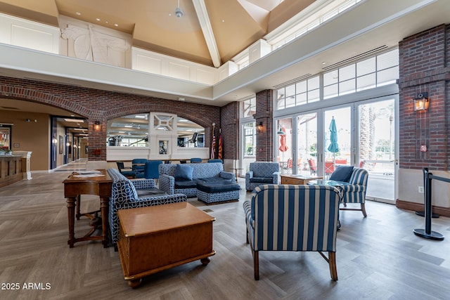 living room with a high ceiling, brick wall, and french doors