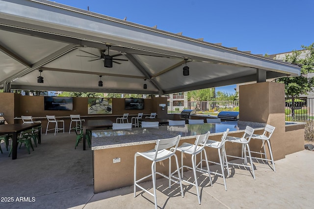 view of patio / terrace with a bar, a gazebo, a grill, and ceiling fan