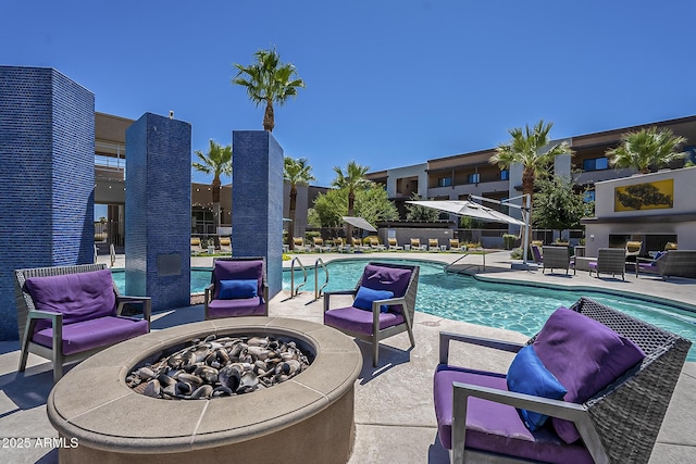 view of pool featuring an outdoor fire pit and a patio