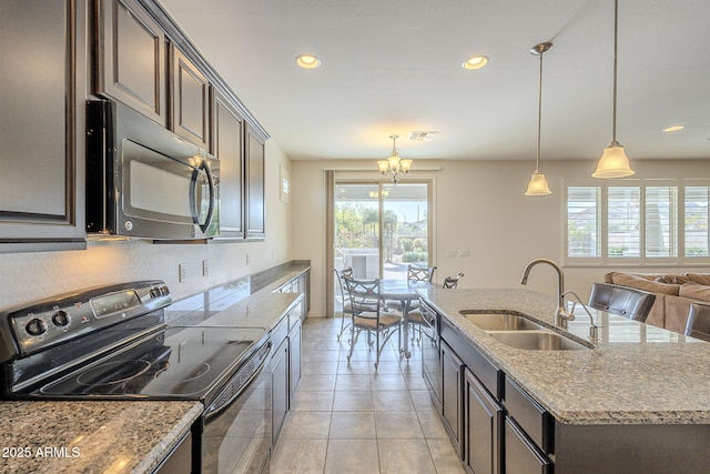 kitchen featuring black appliances, sink, hanging light fixtures, a center island with sink, and dark brown cabinets