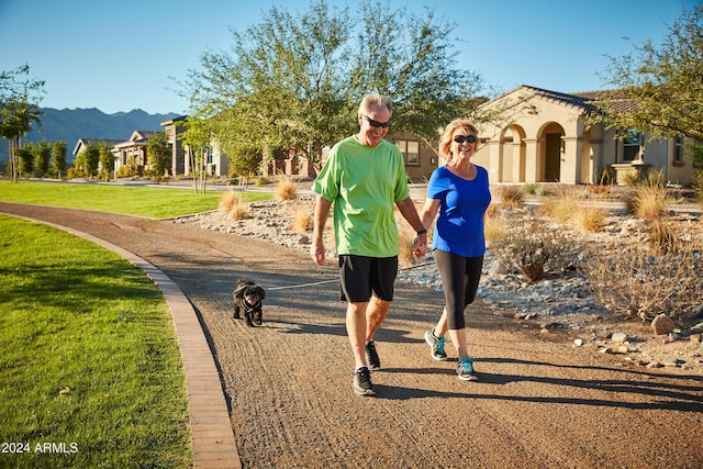 surrounding community with a mountain view and a yard