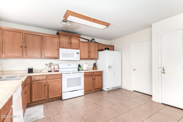 kitchen featuring sink, white appliances, and light tile patterned floors