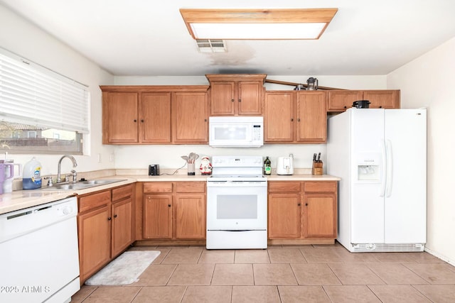 kitchen with light tile patterned flooring, white appliances, and sink