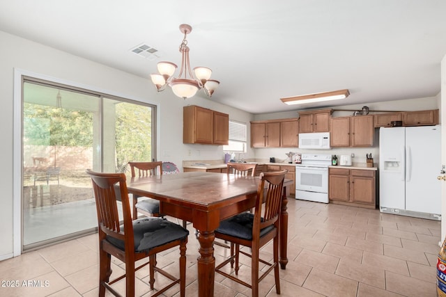 dining area featuring sink, light tile patterned floors, and a notable chandelier