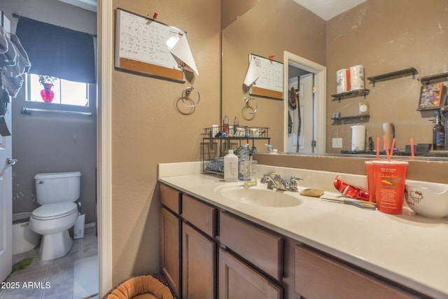 bathroom featuring vanity, tile patterned floors, and toilet