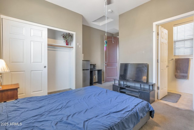 carpeted bedroom with stainless steel fridge and a closet