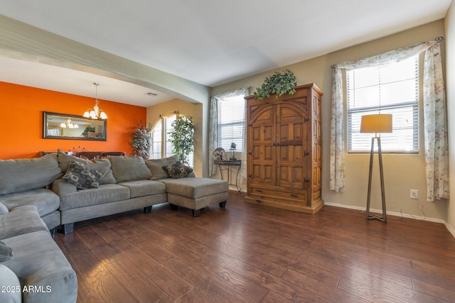 living room featuring a notable chandelier and dark hardwood / wood-style flooring