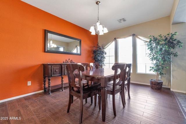 dining area with dark hardwood / wood-style floors and a chandelier