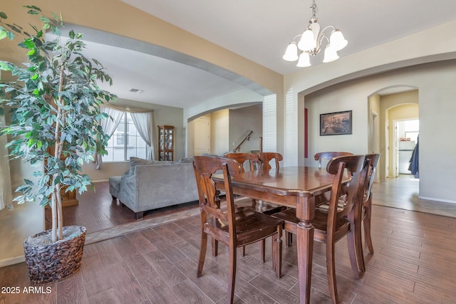 dining area with dark hardwood / wood-style floors and a chandelier