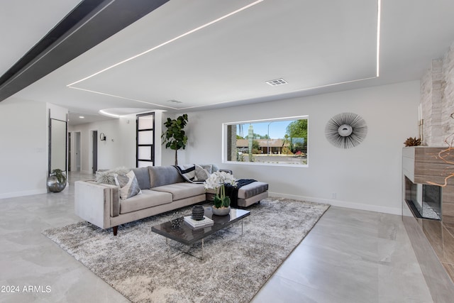 tiled living room with a stone fireplace