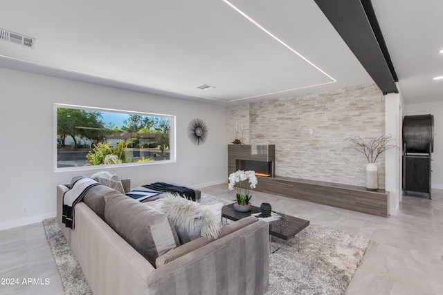 living room with a stone fireplace and tile flooring