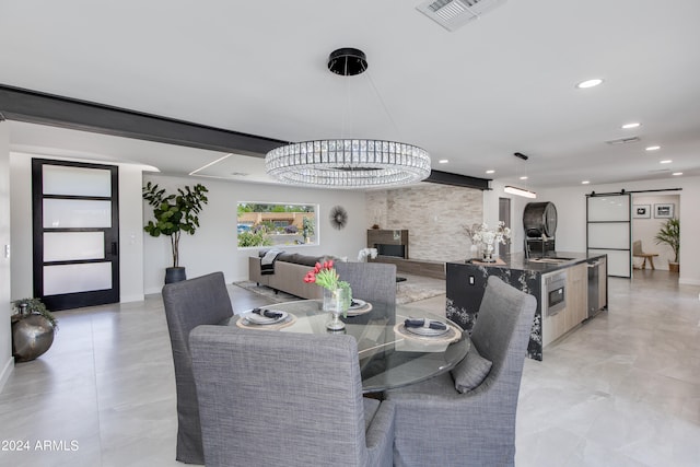 dining area with a barn door, sink, and light tile floors