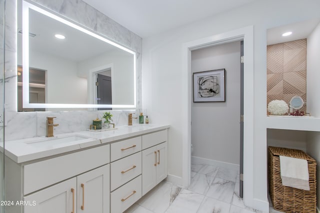 bathroom featuring tile floors, vanity with extensive cabinet space, backsplash, and double sink