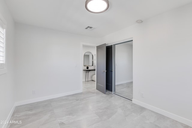 unfurnished bedroom with a closet and light tile floors