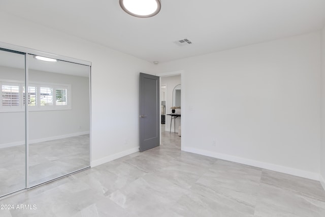 unfurnished bedroom featuring a closet and light tile floors