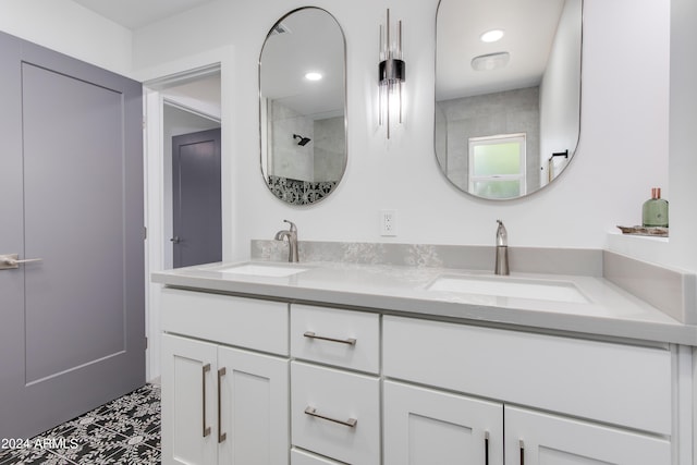 bathroom featuring a tile shower, dual bowl vanity, and tile flooring