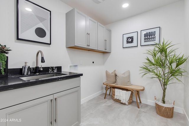 laundry area featuring cabinets, sink, hookup for a washing machine, and light tile floors