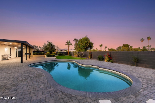 pool at dusk with a patio