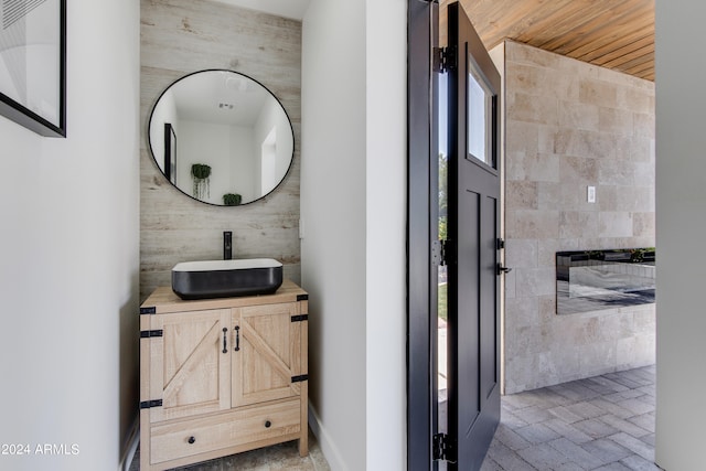 bathroom featuring wooden ceiling, tile flooring, vanity, and tile walls