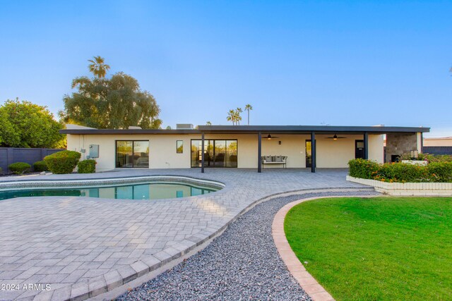 view of swimming pool with a patio area, ceiling fan, and a lawn