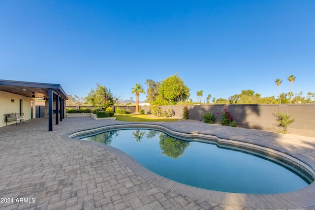 view of swimming pool with ceiling fan and a patio area