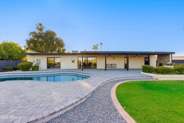 view of swimming pool featuring a patio, ceiling fan, and a lawn