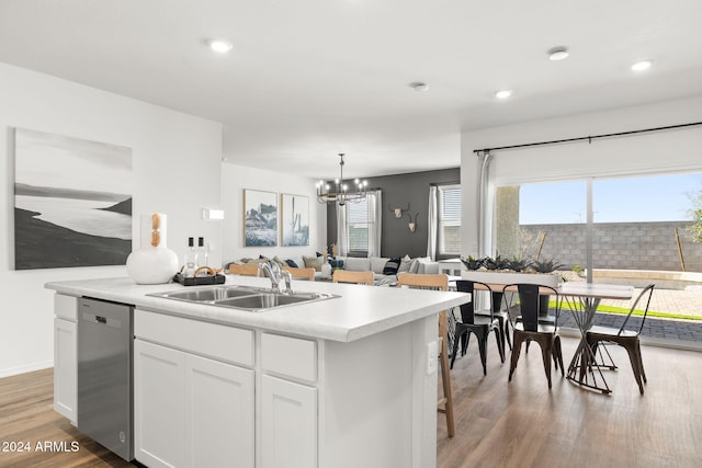 kitchen with sink, stainless steel dishwasher, a chandelier, a kitchen island with sink, and white cabinets