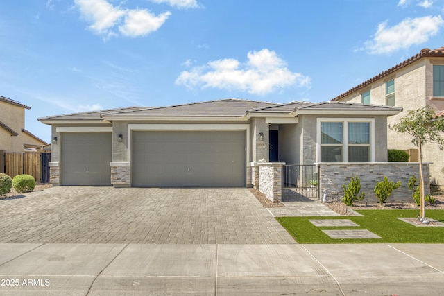 17976 W Ashley Dr, Goodyear, AZ 85338 - prairie-style home with decorative driveway, an attached garage, stone siding, stucco siding, and a tiled roof