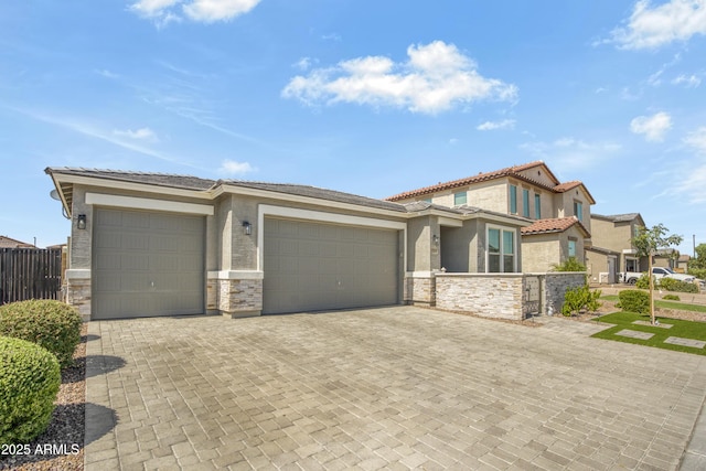 17976 W Ashley Dr, Goodyear, AZ 85338 - view of front facade featuring stucco siding, a tiled roof, an attached garage, and stone siding