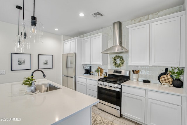 17976 W Ashley Dr, Goodyear, AZ 85338 - kitchen featuring wall chimney range hood, appliances with stainless steel finishes, white cabinetry, light countertops, and backsplash