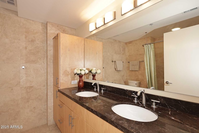 full bath featuring toilet, a shower with curtain, visible vents, and a sink