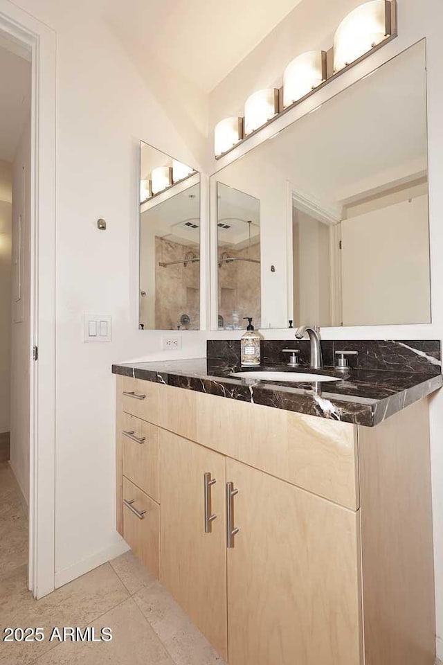 full bathroom with double vanity, tile patterned flooring, and a sink