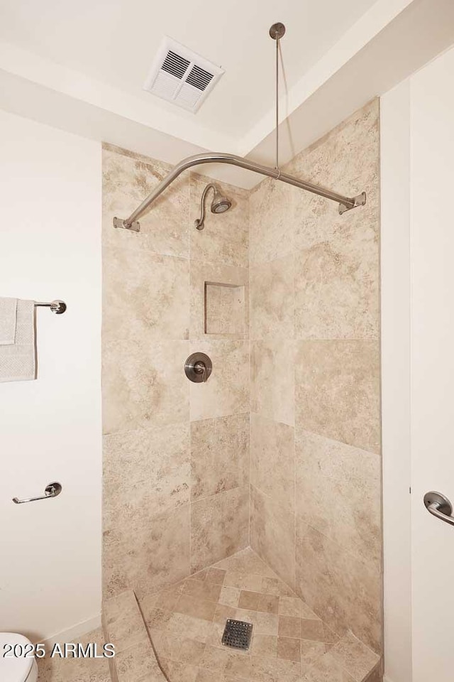 bathroom with visible vents and tiled shower