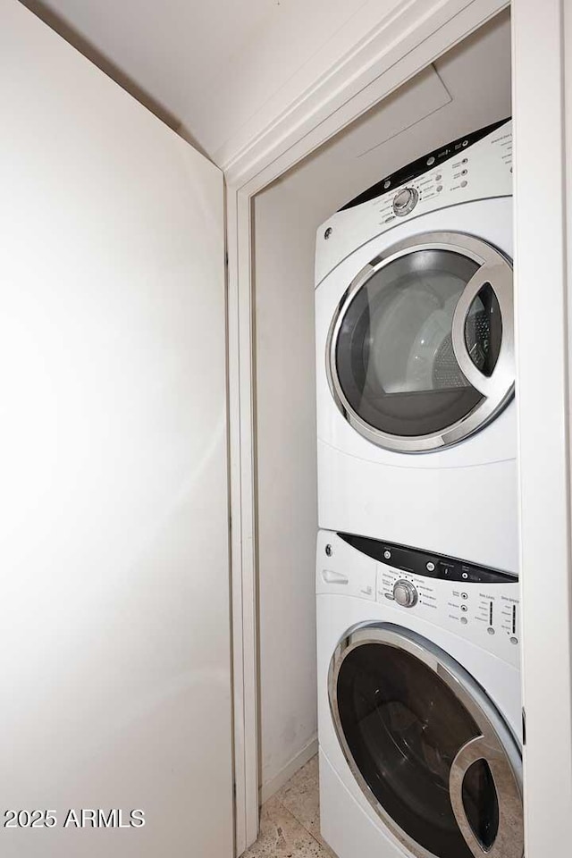 washroom featuring stacked washer and dryer and laundry area