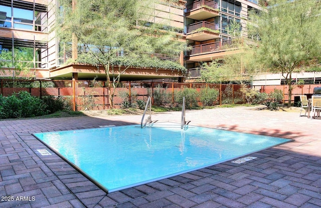 view of swimming pool with a patio area and fence