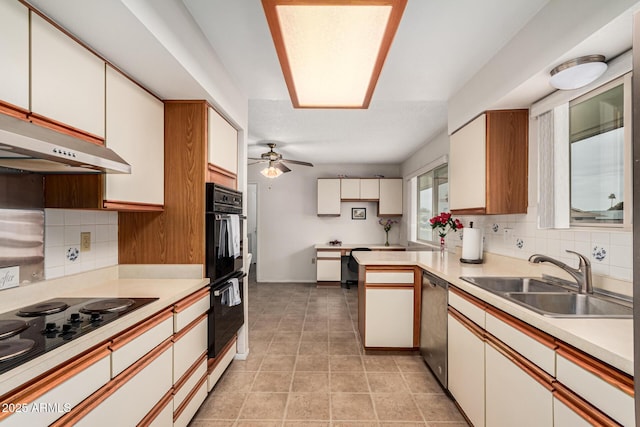 kitchen featuring black appliances, tasteful backsplash, light countertops, and a sink