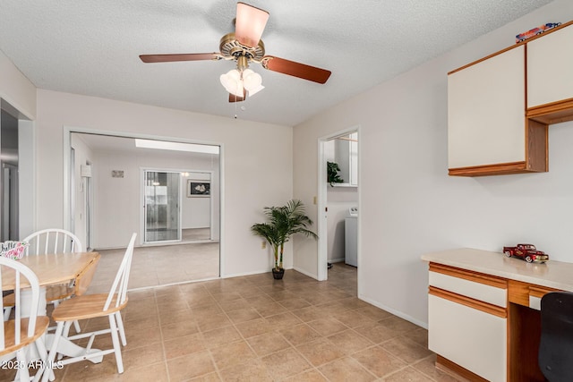 dining room featuring a ceiling fan, washer / clothes dryer, a textured ceiling, and baseboards