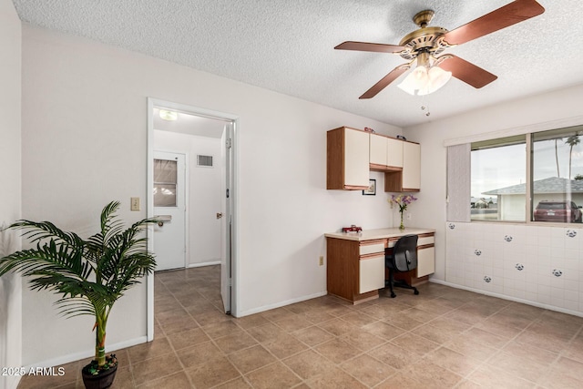 office area with visible vents, ceiling fan, a textured ceiling, and baseboards